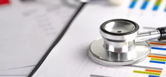 A stethoscope resting on some paper with biometric data.