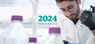 A pharmaceutical researcher in a lab, overlaid with the text "2024 Year in Review".