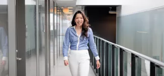 Dr. Mary De Vera walking down a hall.