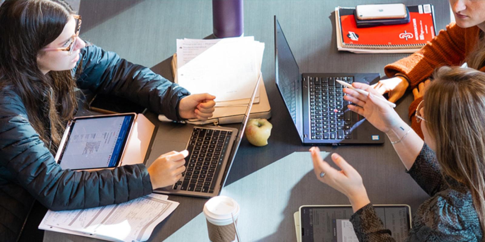 A top-down view of three students working at a table.