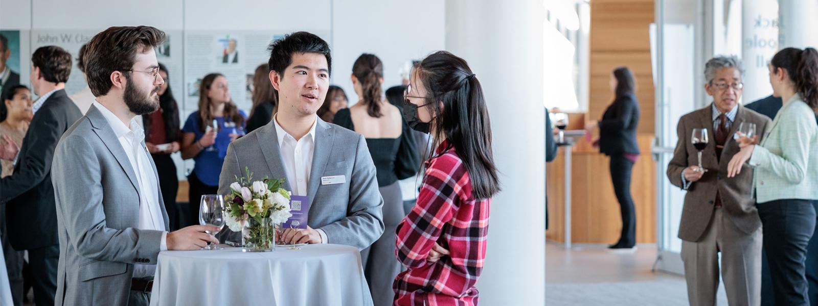 Three professionals mingling at an event.